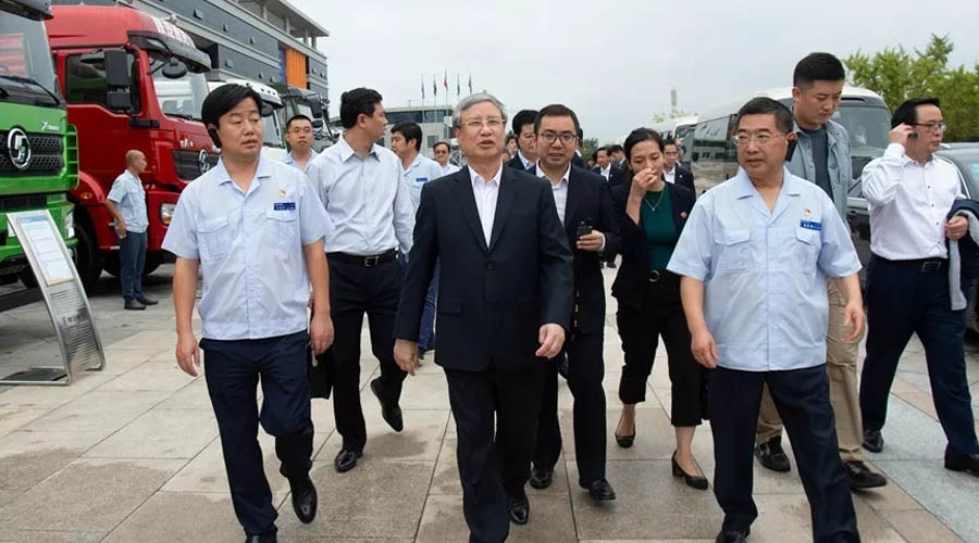 In front of the exhibition trucks, Chen Guowang watched and took photos with the Delong series cargo trucks, the new environmentally-friendly muck trucks, the hydrogen fuel cell sprinklers, the pure electric kitchen garbage trucks and the military vehicles.